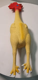A rubber chicken toy with a yellow body and a red comb.