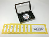 A set of yellow index cards with inspirational quotes, displayed in front of a small metal case with a clear lid, which contains a spinning wheel with a quote on it.