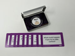 A set of purple conflict resolution cards displayed alongside their packaging, with visible text on the cards posing various conflict resolution questions.