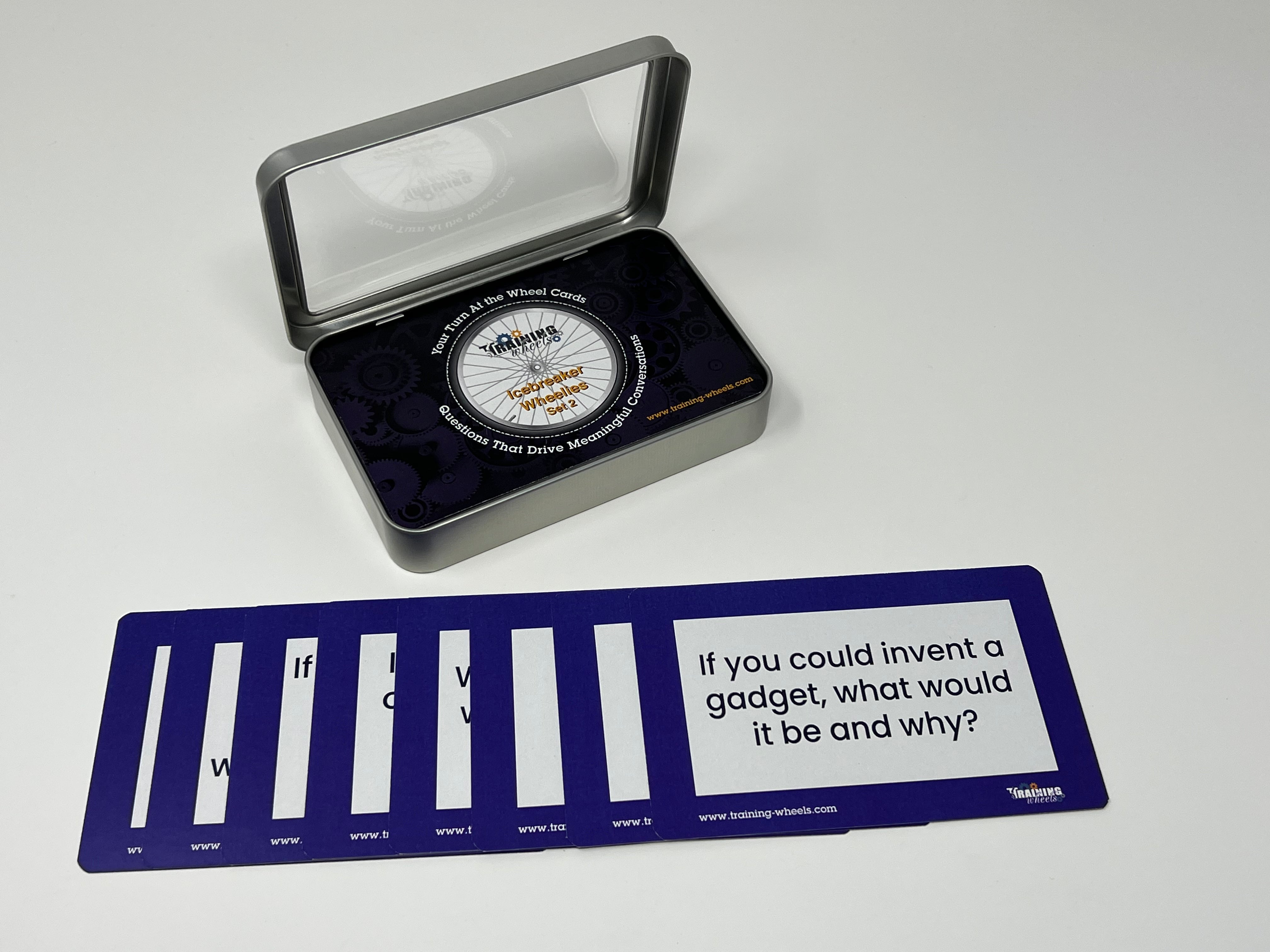 A set of icebreaker question cards displayed outside a clear plastic case, with the case lid showing the product title 'Icebreaker Wheelies, Set 2'.