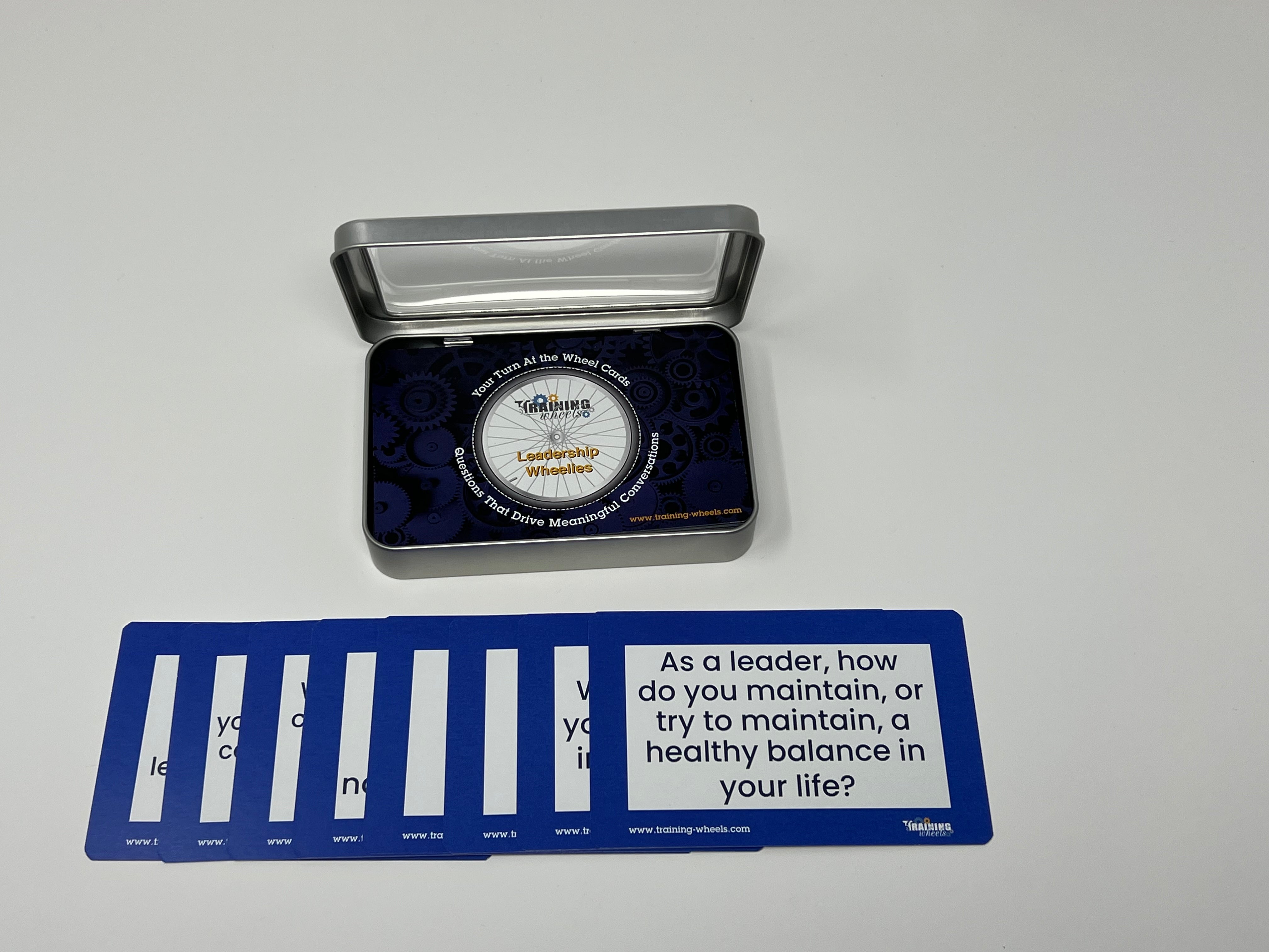 Leadership Wheelies card deck with 65 reflective leadership questions in a plastic container, ideal for group activities and personal growth.