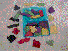 Blind Shapes activity set with colorful hand-dyed wooden shapes, nylon bag, and instruction sheet for group diversity and curiosity activities.