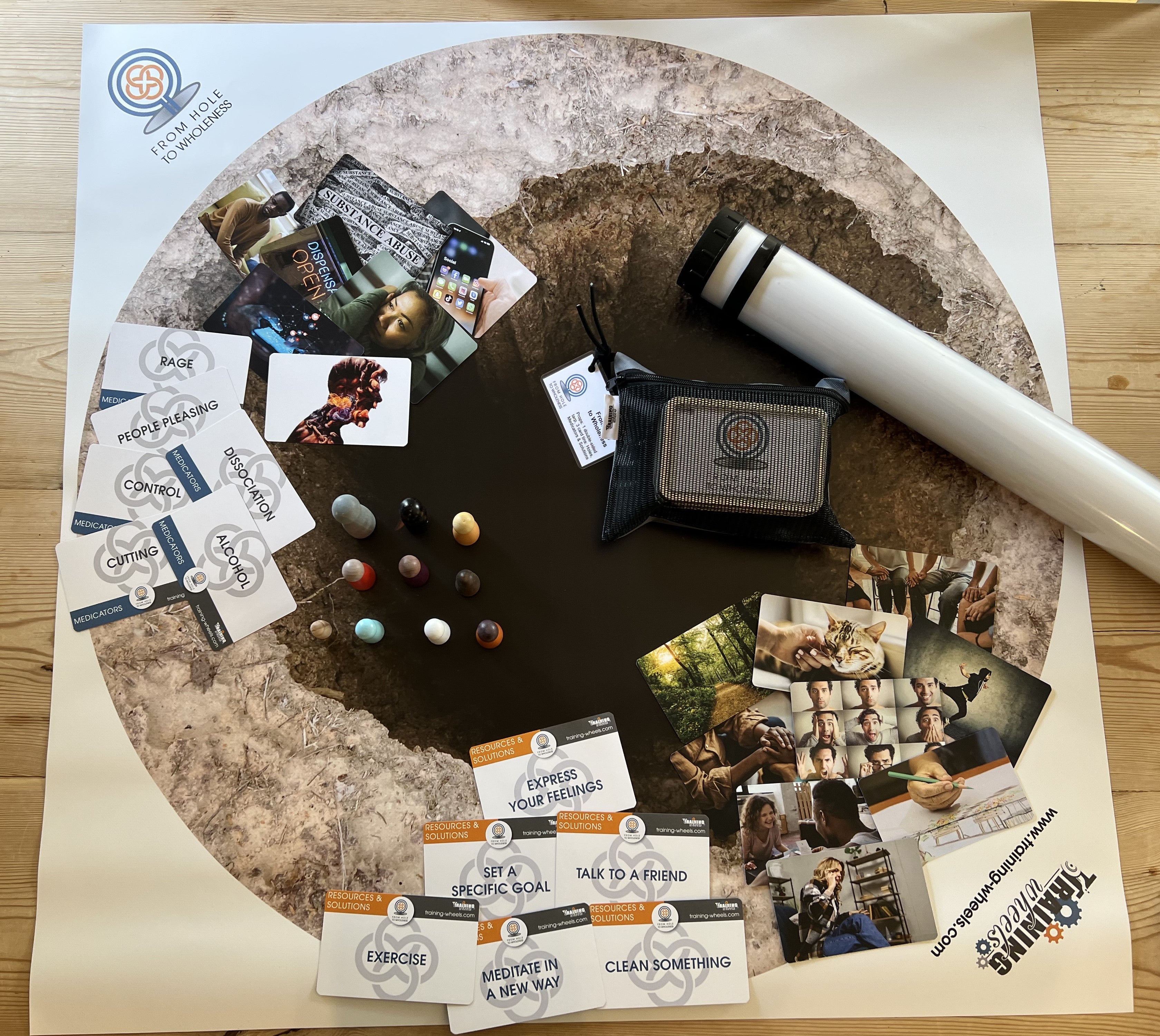 Hole to Wholeness activity set with double-sided tarp, three card decks (Medicators, Resources & Solutions, Metaphor Cards), and game pieces for experiential recovery discussions.