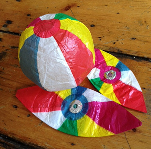 A colorful paper beach ball with visible folds and a plastic fastener.