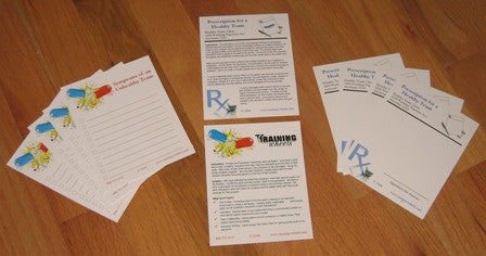 A set of Rx Debrief Prescription Cards and Facilitator Notes displayed in a clear plastic envelope, symbolizing team diagnosis and healing.