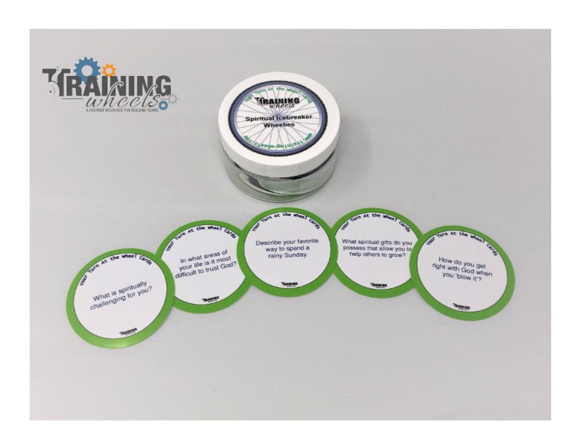 A set of round, green cards with spiritual icebreaker questions laid out in a row in front of a plastic container with a label.