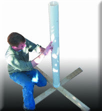 Participants working together to retrieve an object from a vertical PVC tube using water and limited resources during a team-building activity.