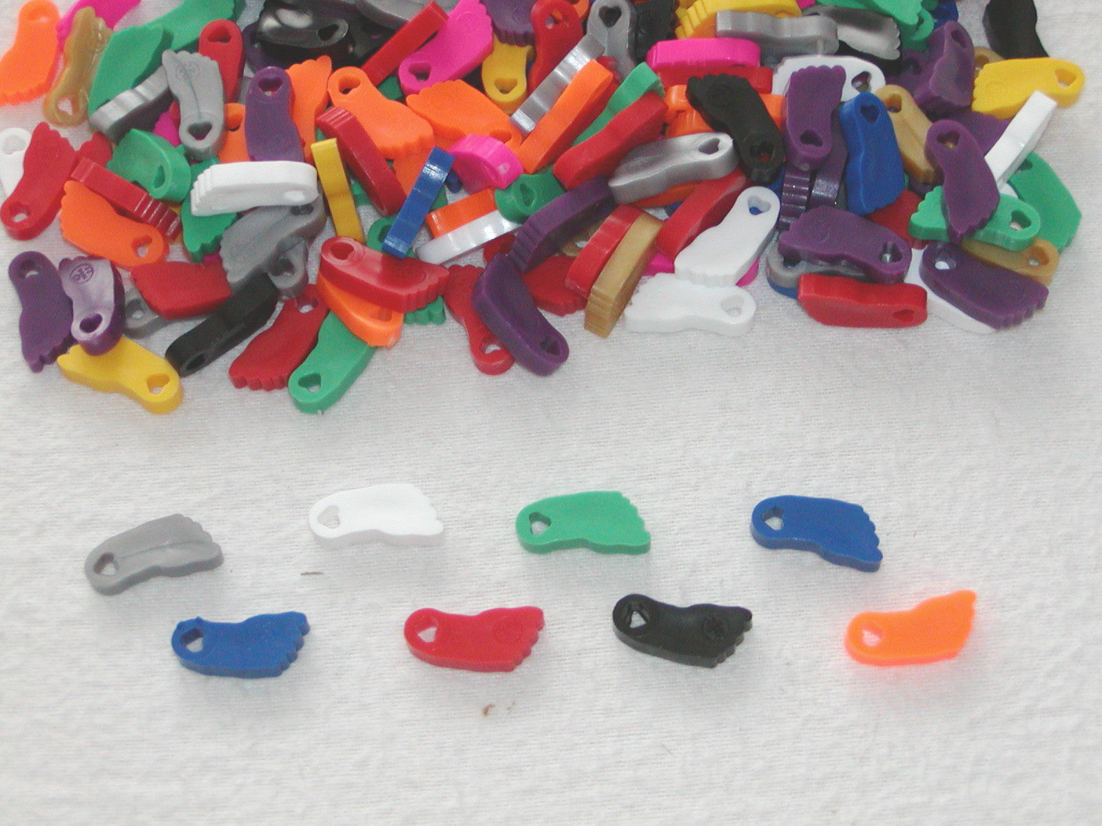 A collection of colorful plastic feet with heart-shaped cutouts, arranged in a circle for group recognition.