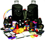 Two large black rolling suitcases standing behind a large assortment of packed travel items, including backpacks, bags, clothing, toiletries, and small accessories, all arranged on a white studio background.